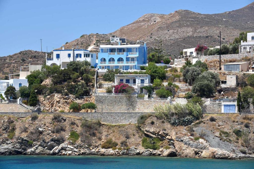 ein blaues Haus auf einem Hügel neben dem Wasser in der Unterkunft Villa 9 Muses in Vári