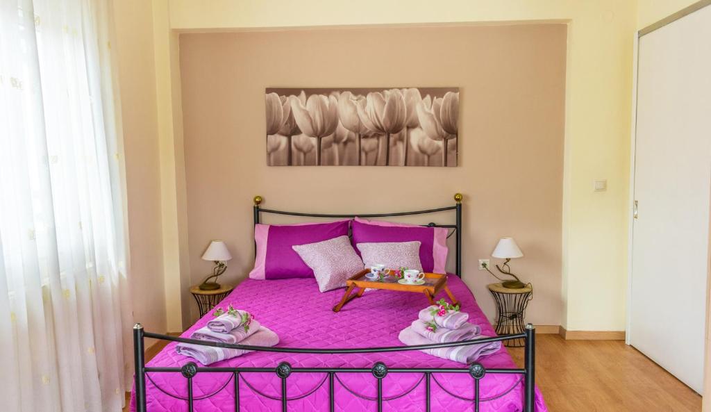 a bedroom with a pink bed with pink sheets at Spiti Anna Maria in Corfu