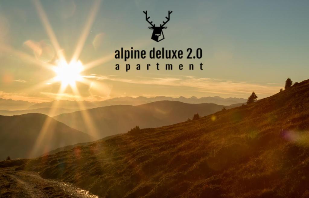 里斯孔內的住宿－Alpine Deluxe 2.0，一张有太阳背景的山的照片