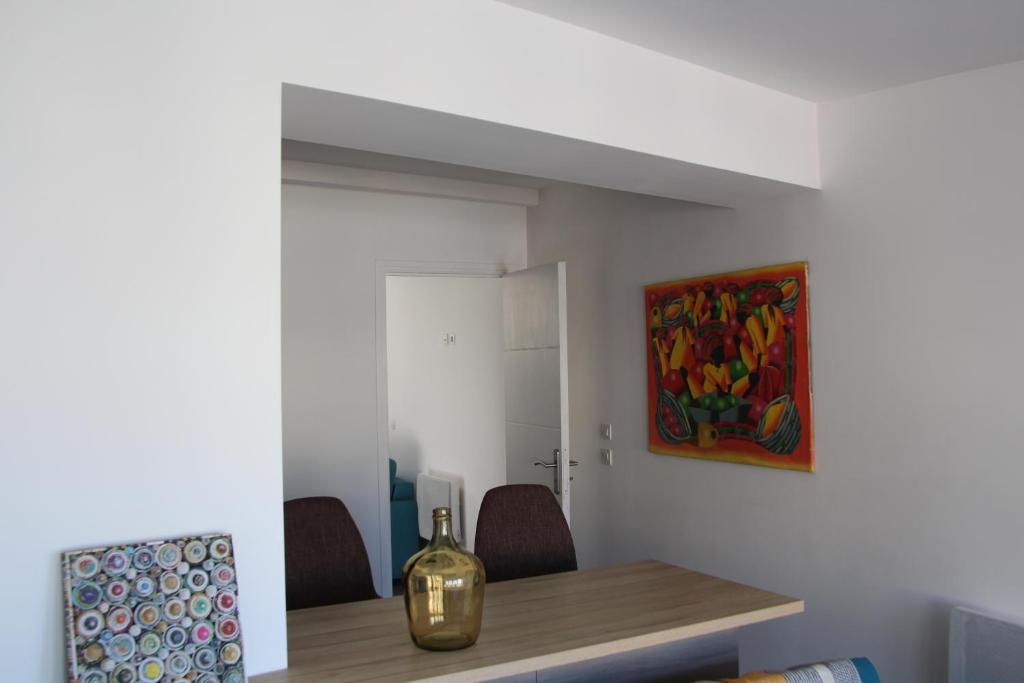 a dining room with a table and a painting on the wall at Charmant Cabanon aux Goudes à Marseille avec vue mer in Marseille