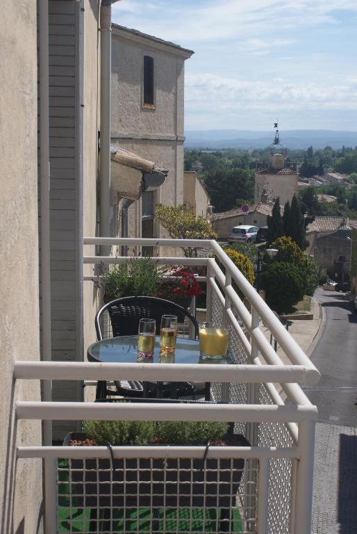 a balcony with a table with two glasses on it at maly appart avec balcon et 1 studio en rez-de-chaussée in Vedène