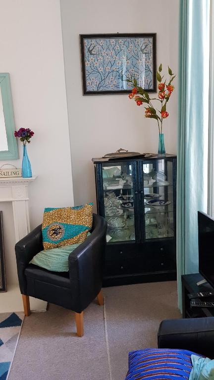 a living room with a chair and a fish tank at Andorinho Sea View Apartment in Margate