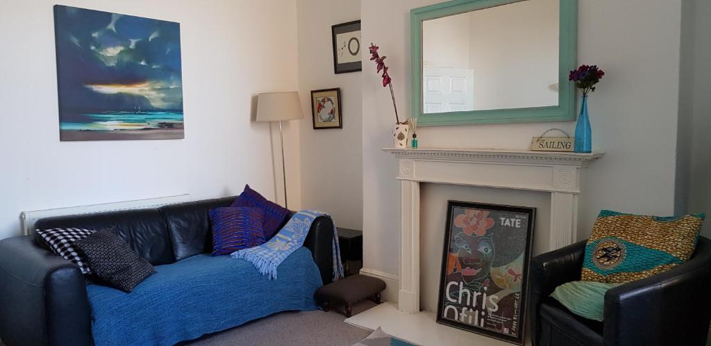 a living room with a couch and a fireplace at Andorinho Sea View Apartment in Margate