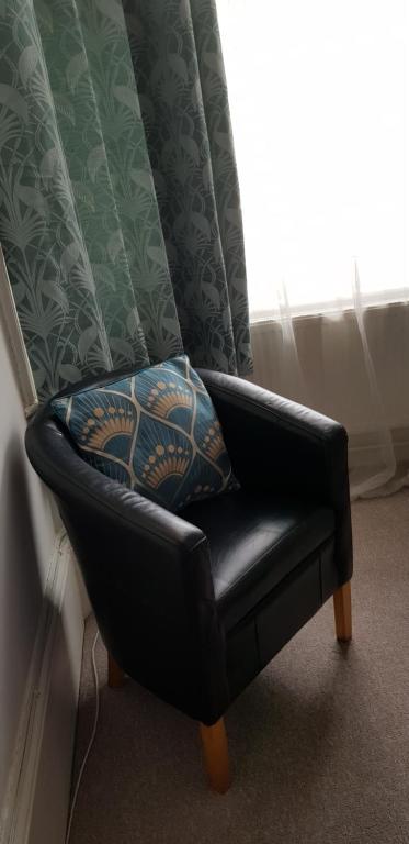 a black leather chair sitting in a room with a window at Andorinho Sea View Apartment in Margate