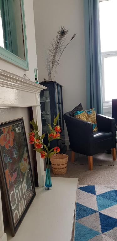 a living room with a fireplace and a chair at Andorinho Sea View Apartment in Margate