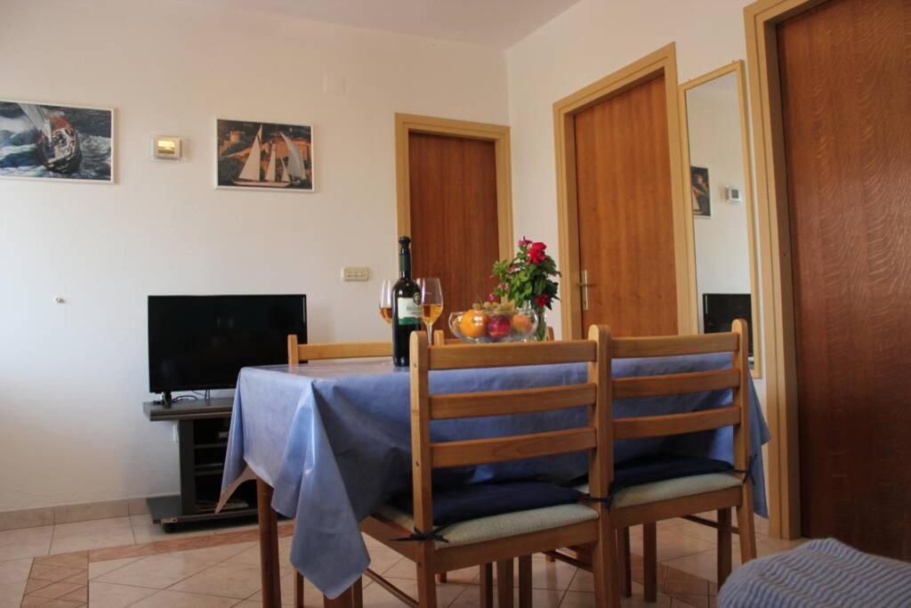 a dining room table with a blue table cloth on it at Orhideja Apartment in Lukoran