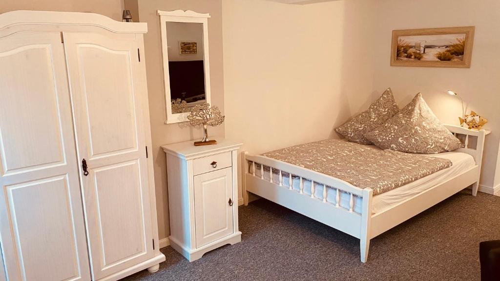 ein kleines Schlafzimmer mit einem Bett und einem Schrank in der Unterkunft Moin.Moin 2 in Grömitz