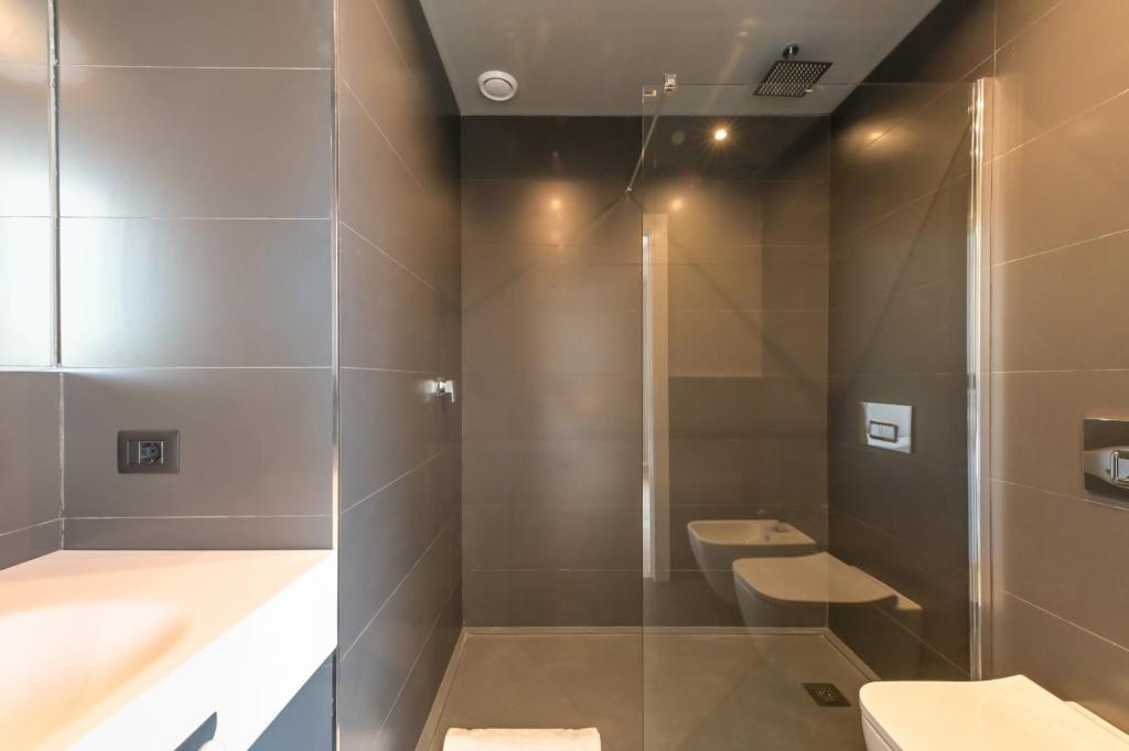 a bathroom with two toilets and a glass shower at Hotel Punta Tipa in Trapani