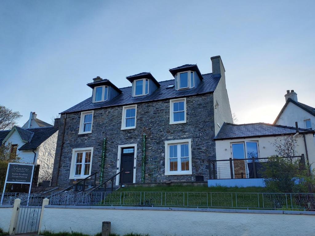 a large stone house with a black roof at Seaview Guesthouse in Mallaig