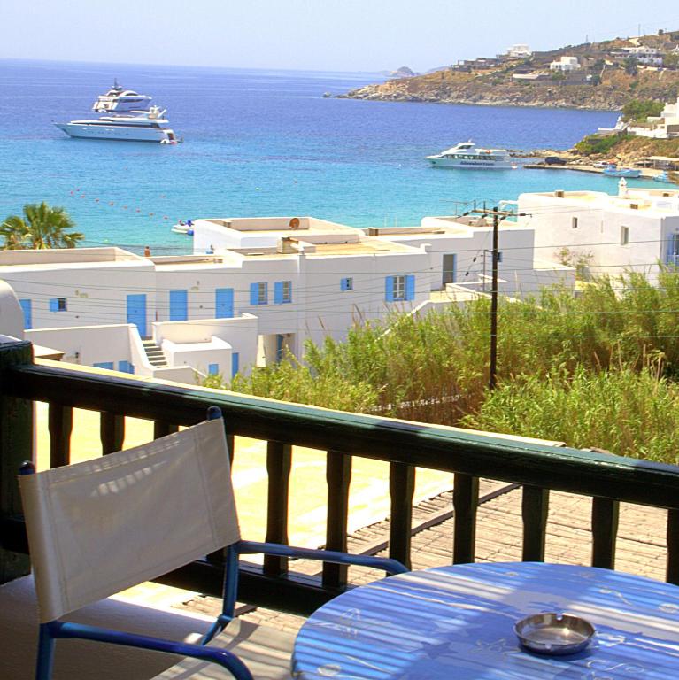 a balcony with a table and a view of the ocean at Studios Flora Manos in Platis Gialos