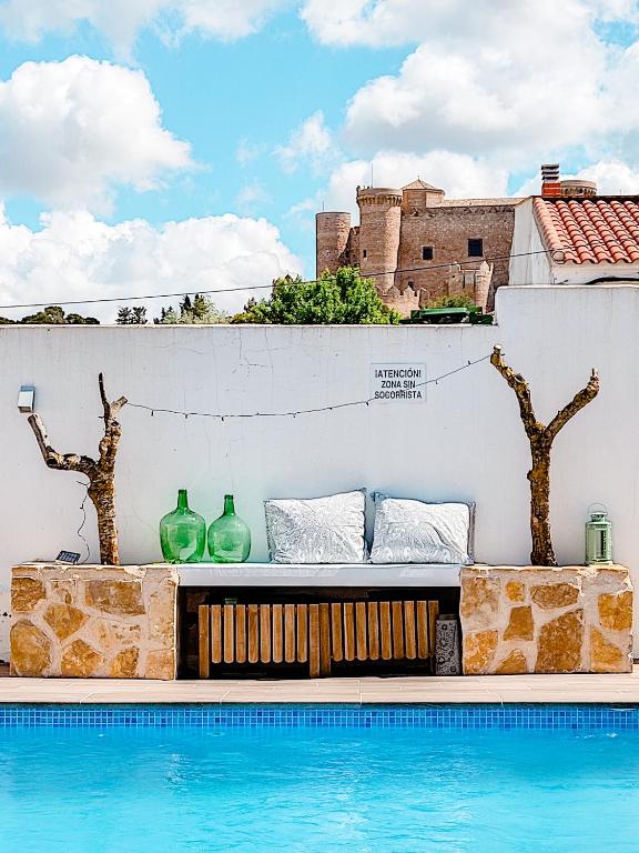 a bench next to a swimming pool with vases at Insula Barataria in Belmonte