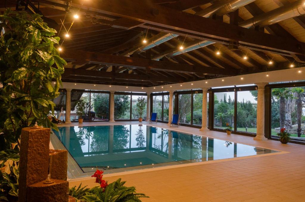 a large indoor swimming pool in a building with windows at LO CLAUSTRE DEL DELTA- LUX FINCA in Delta del Ebro - FINCA PRIVADA -NO HAY NINGUN SERVICIO HOTELERIA- SOLO ALOJAMIENTO in Sant Carles de la Ràpita