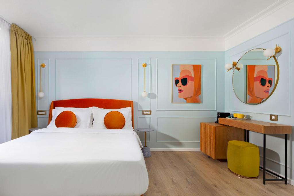 a bedroom with a bed and a desk with a mirror at De Cardo Hotel in Jerusalem