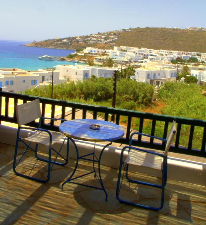 a table and chairs on a balcony with a view of the ocean at Studios Flora Manos in Platis Gialos
