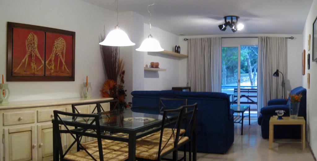 uma sala de estar com uma mesa e um sofá azul em Vivienda en residencial con piscina em Garrucha