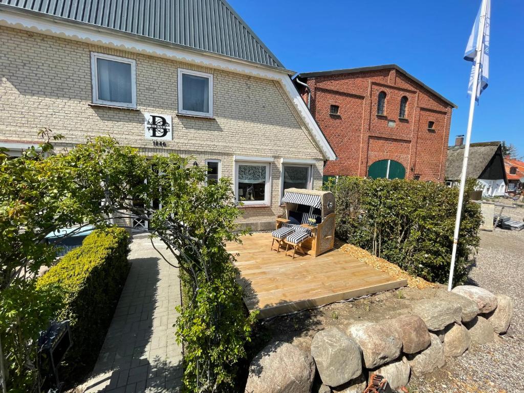 a house with a bench on a wooden deck at Ferienwohnung Ententeich in Fehmarn