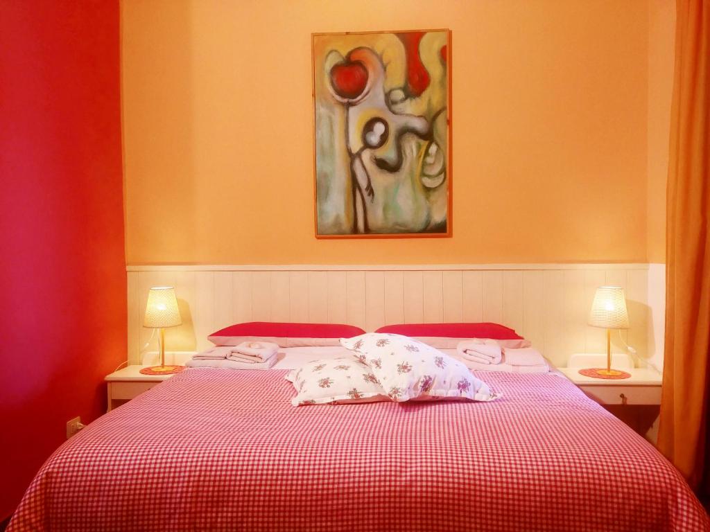 a bedroom with a bed with a red and white blanket at B&B Casa Di Pam in Scicli