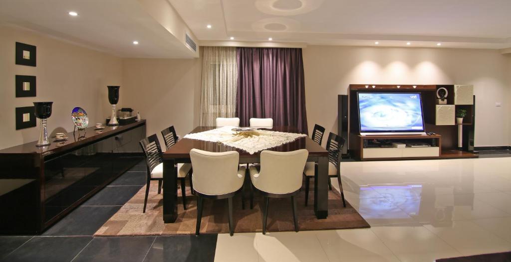 una sala da pranzo con tavolo e TV di AlAshrafia Smart Residence a Il Cairo