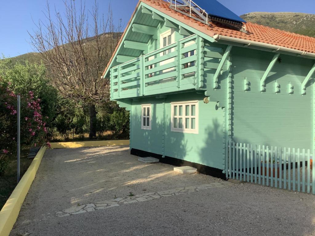 una casa verde con una valla blanca en un aparcamiento en THE CABIN, KYPARISSIA, en Kyparissia