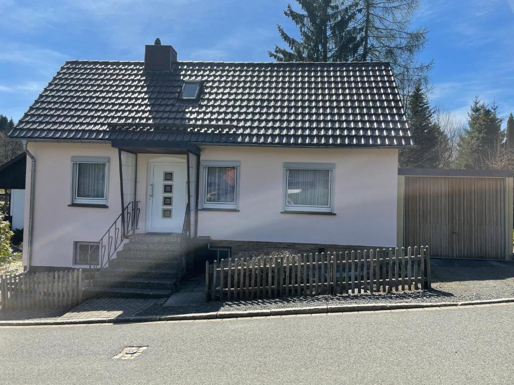 una casa blanca con una valla delante en Ferienhaus Bockswiese en Goslar