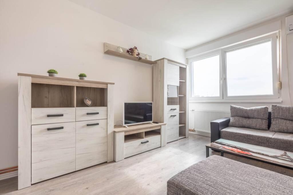 a living room with a couch and a television at Cosy Apartment Hugo in Osijek