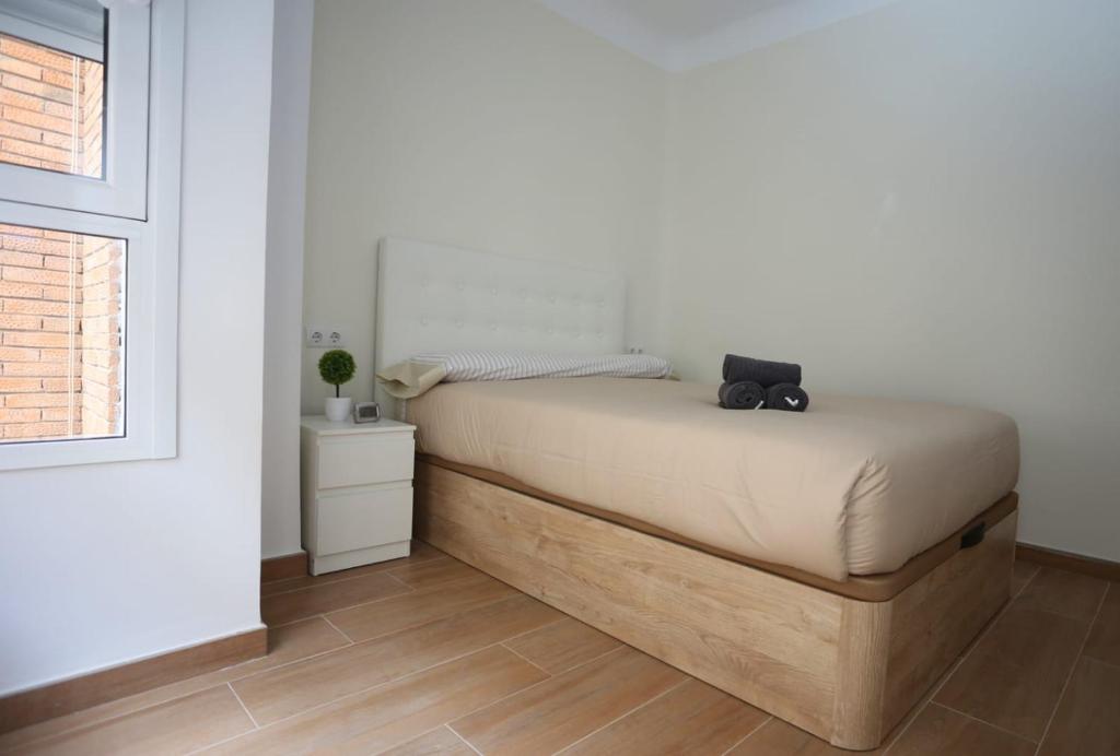 een slaapkamer met een bed met een zwarte tas erop bij Apartamentos Navas GAM in Alicante