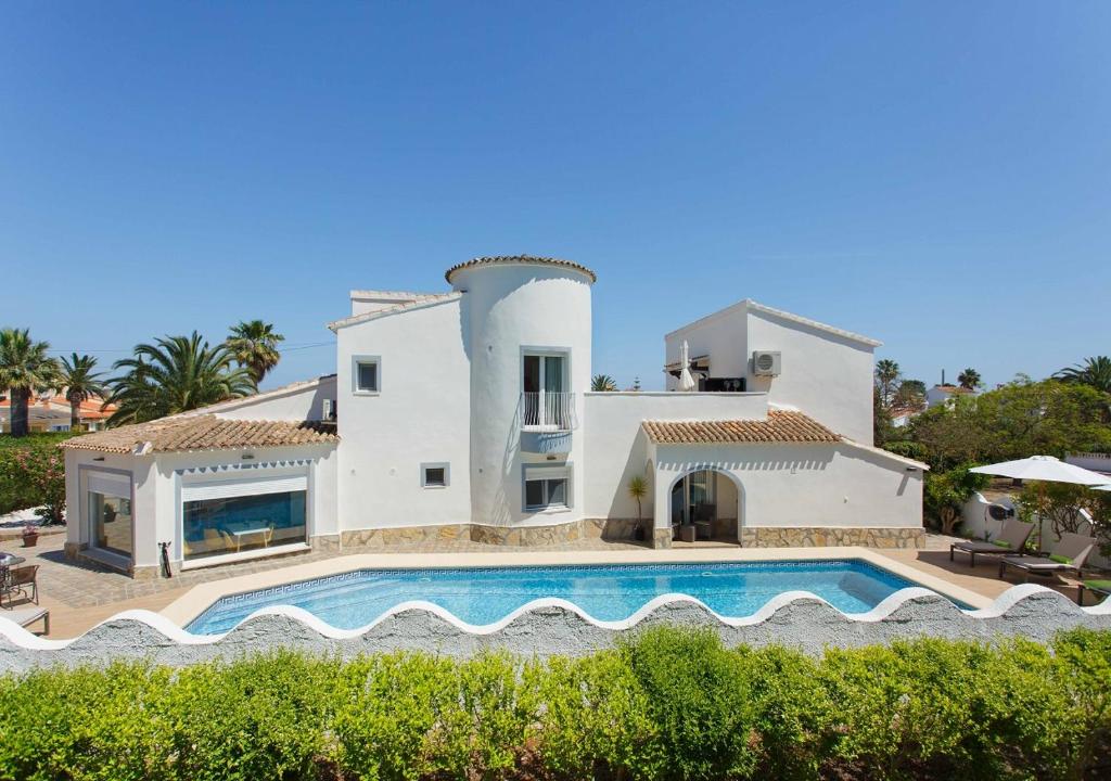 una gran casa blanca con piscina frente a ella en Casa Felizia, en Els Poblets