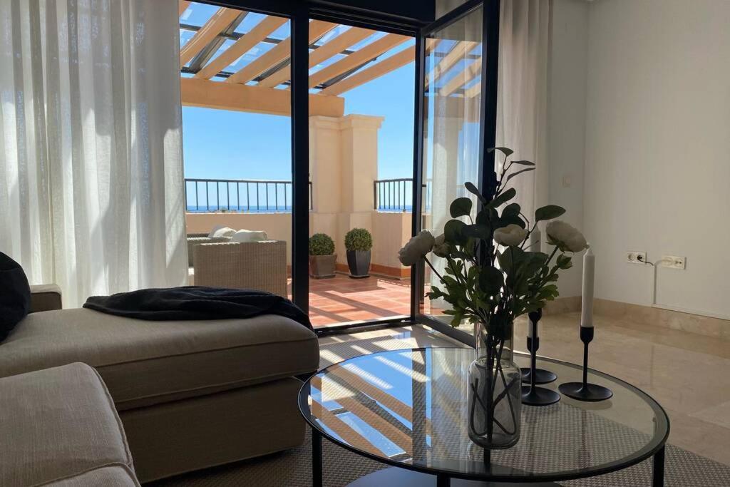 a living room with a couch and a glass table at Penthouse with sea views in Marbella in Marbella