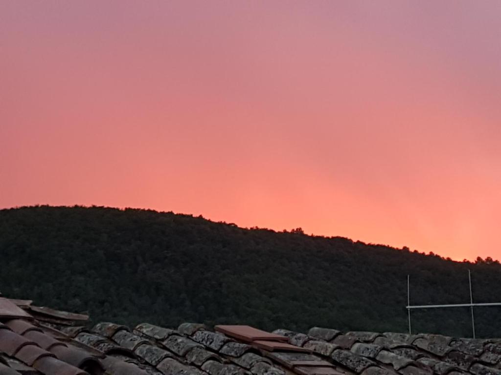 a red sky over a roof of a house at BORGO NEL TEMPO in Collestatte