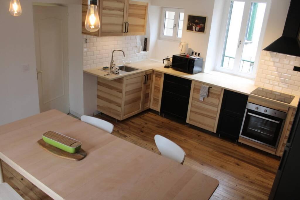 uma cozinha com uma mesa e uma bancada em Résidence prestige - terrasse - 4 chambres - 3 SDB em Aubière