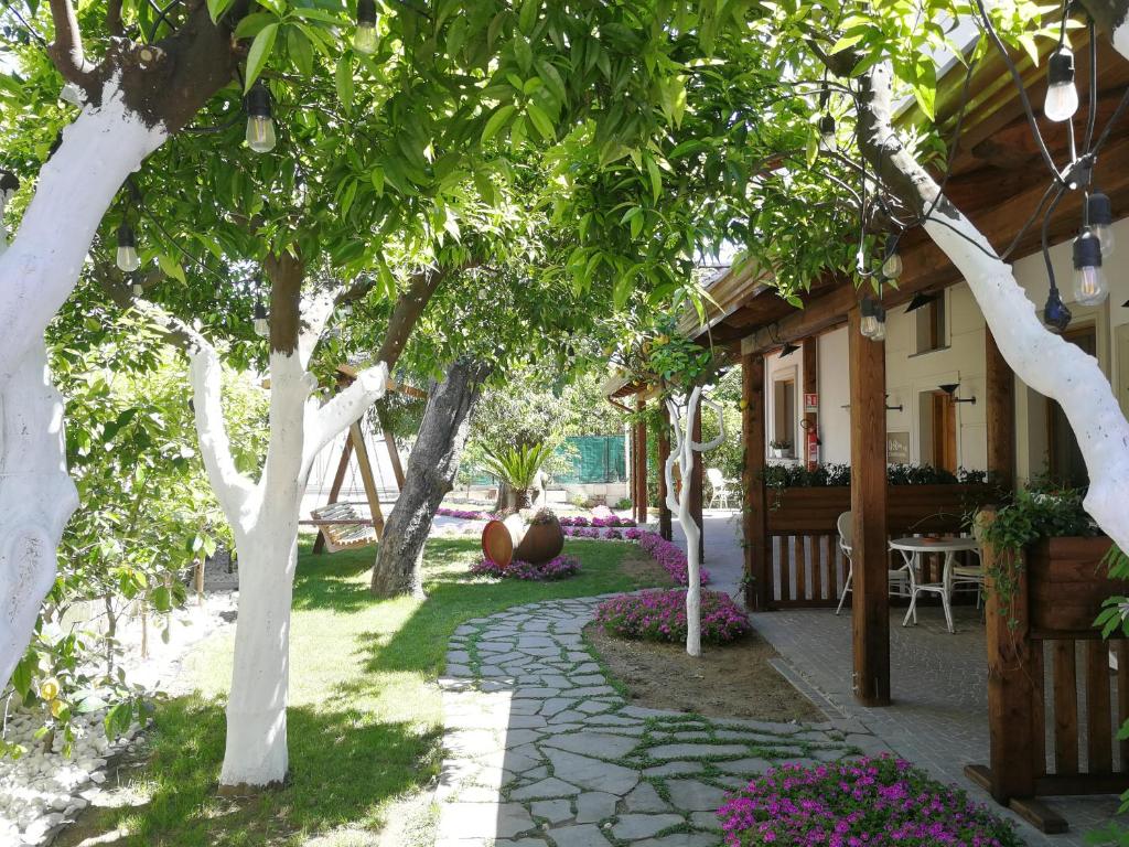 un jardín con árboles y una pasarela de piedra en Relais Country House, en Pompeya