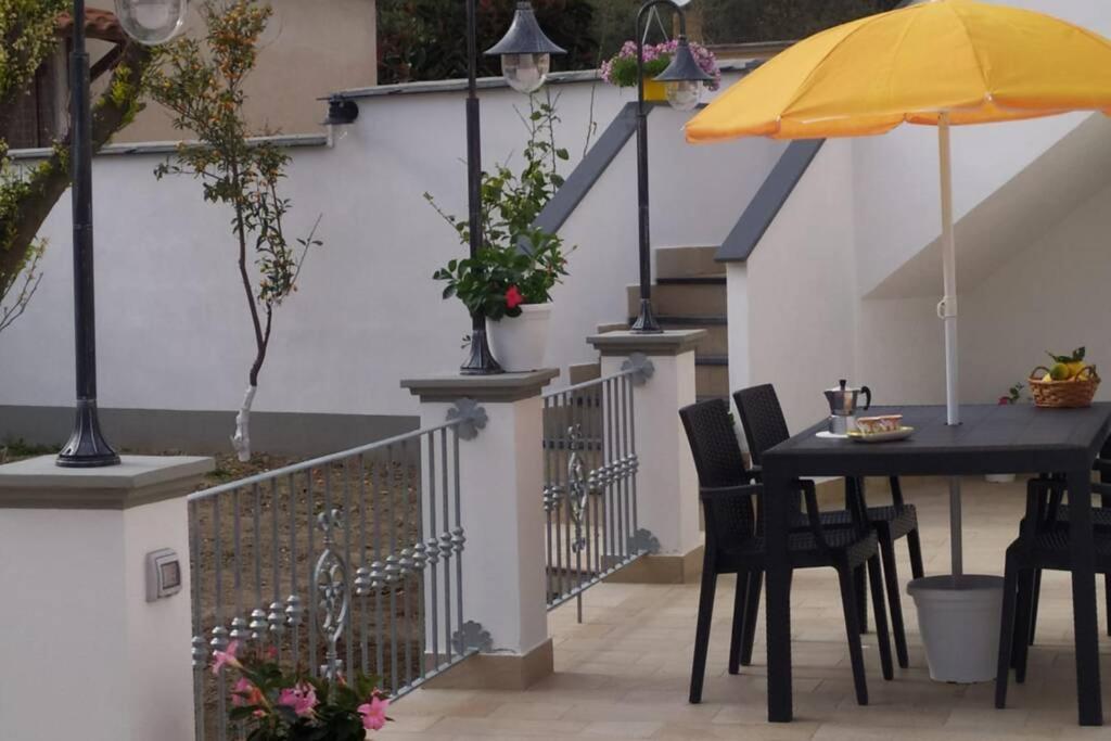 a patio with a table and a yellow umbrella at Casa vacanze Manuel, da Maruzzella in Procida