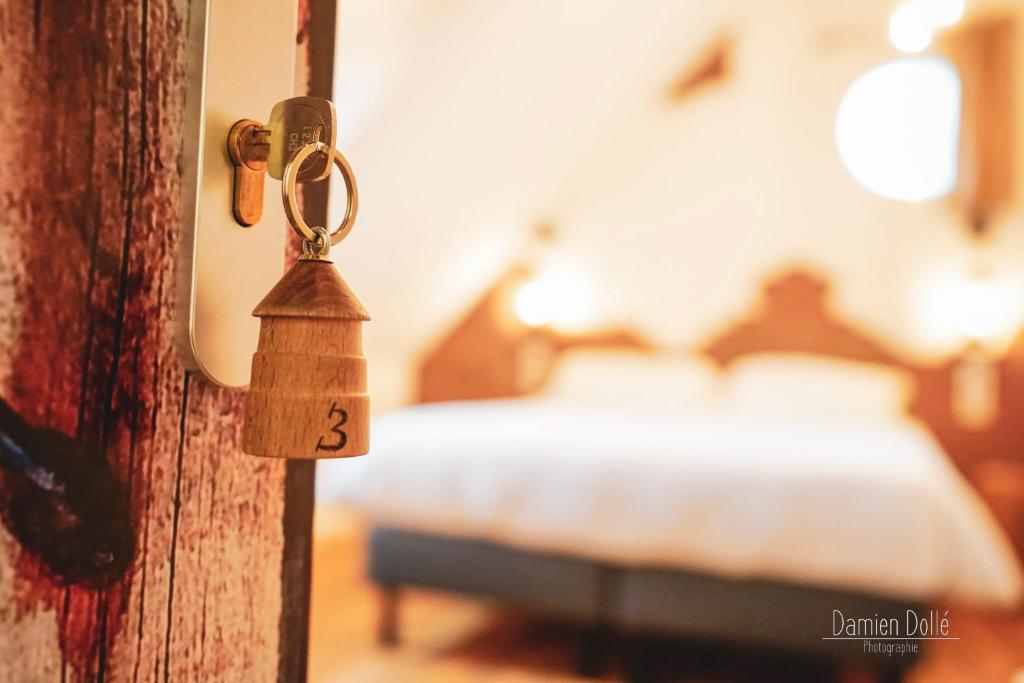 a door with a key in a room with a bed at Le Saltimbanque - Auberge du Moulin in Eaucourt-sur-Somme