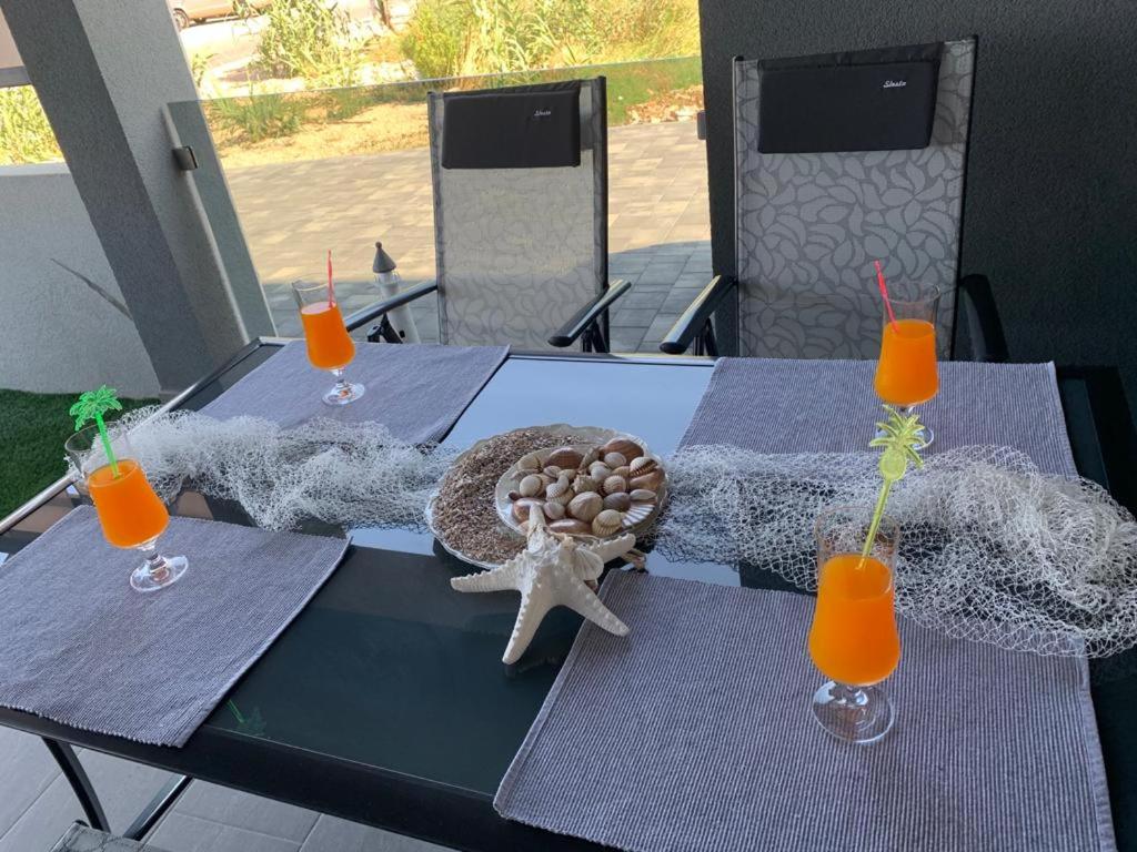 寧的住宿－APARTMANI SUNSIDE NIN，一张桌子,上面放着海星和两杯橙汁
