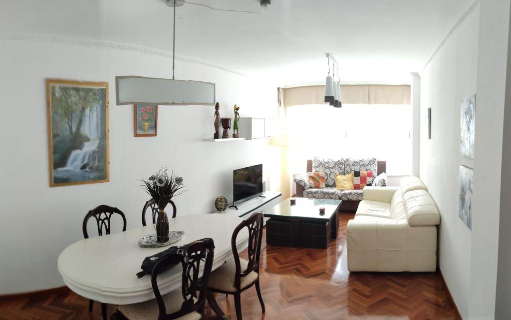 uma sala de estar com uma mesa e um sofá em Cruxa Apartments garaje incluido em Santiago de Compostela