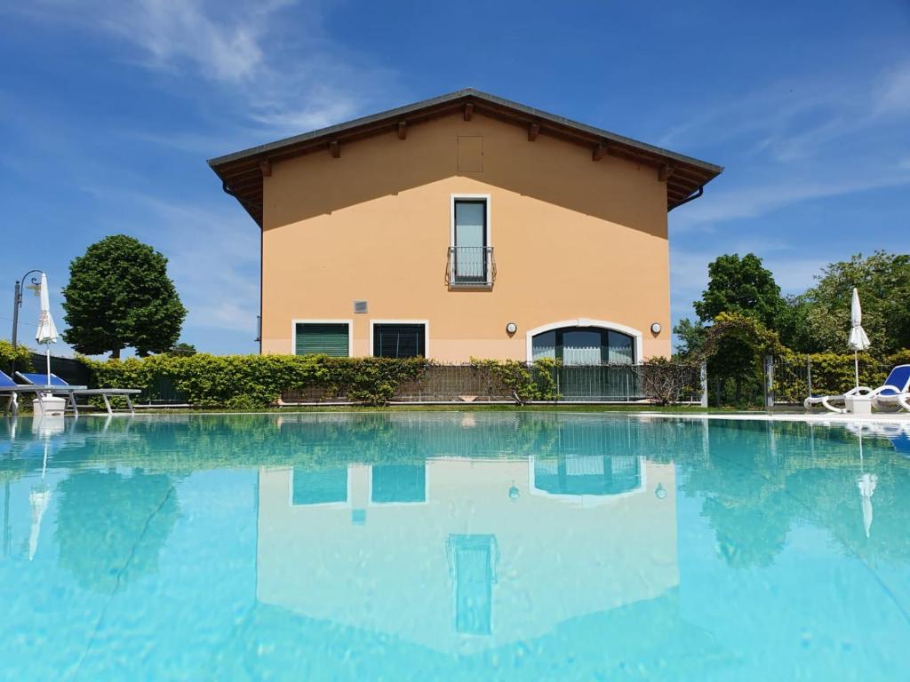 a house with a pool in front of it at Hotel Agli Ulivi in Valeggio sul Mincio