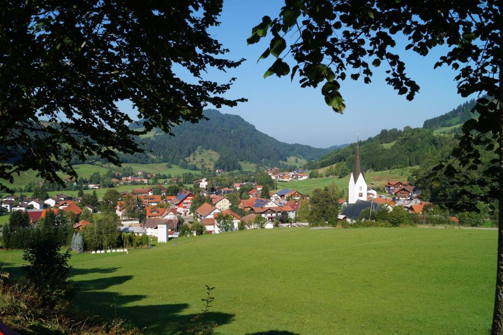 a village with a green field and a church at Ferienwohnung Ritter in Missen-Wilhams