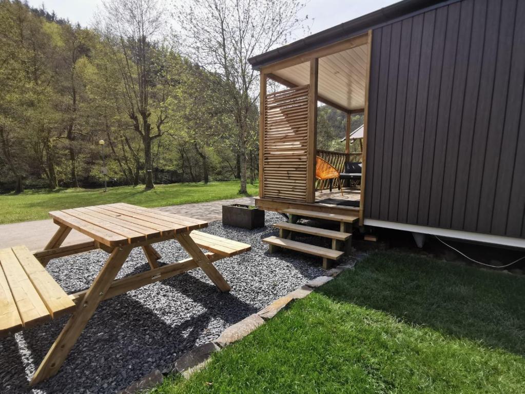 einem Picknicktisch und einer Bank neben einer Hütte in der Unterkunft Chalet Gringlee in Goebelsmuhle