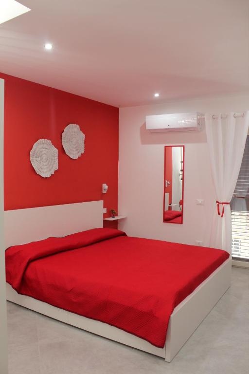 1 dormitorio rojo con 1 cama con manta roja en Maresole Cefalù, en Cefalú