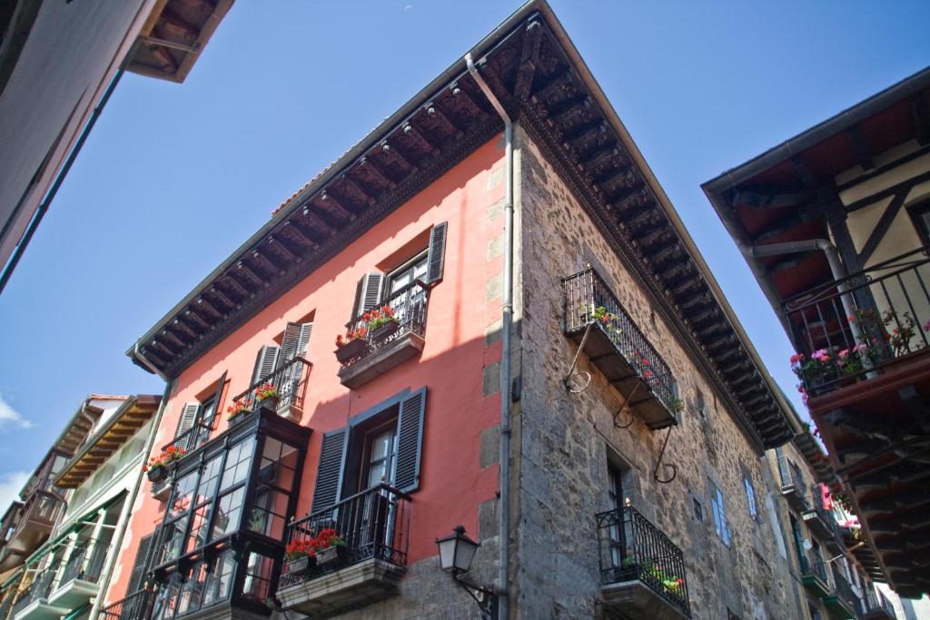 un edificio con ventanas y balcones en una calle en Hotel Palacio Oxangoiti, en Lekeitio