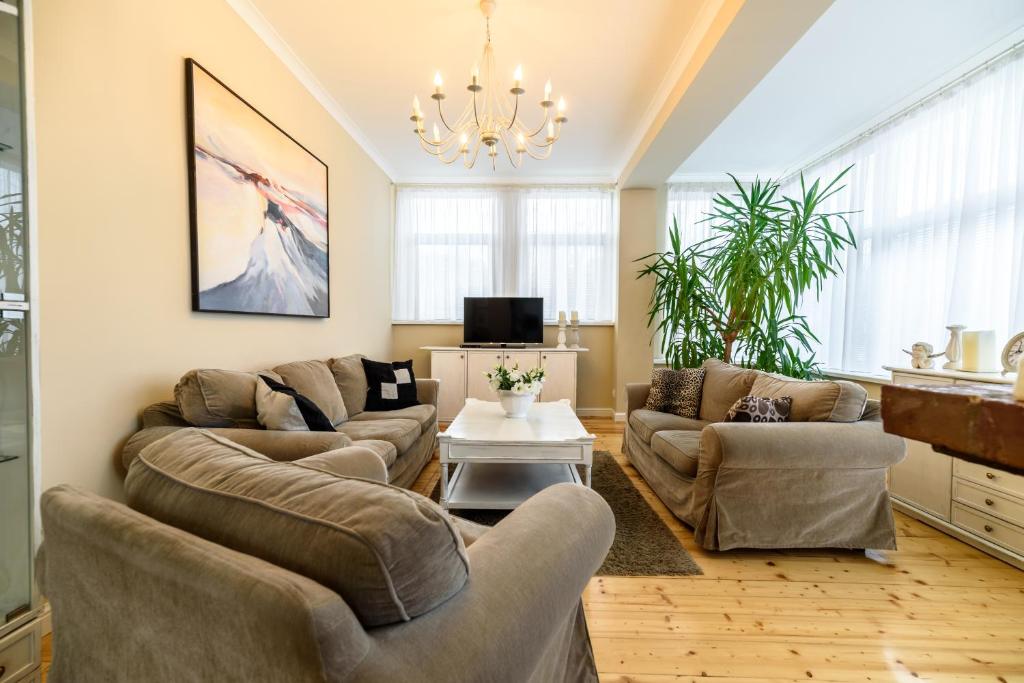 a living room with couches and a chandelier at Apartament Lidia in Duszniki Zdrój