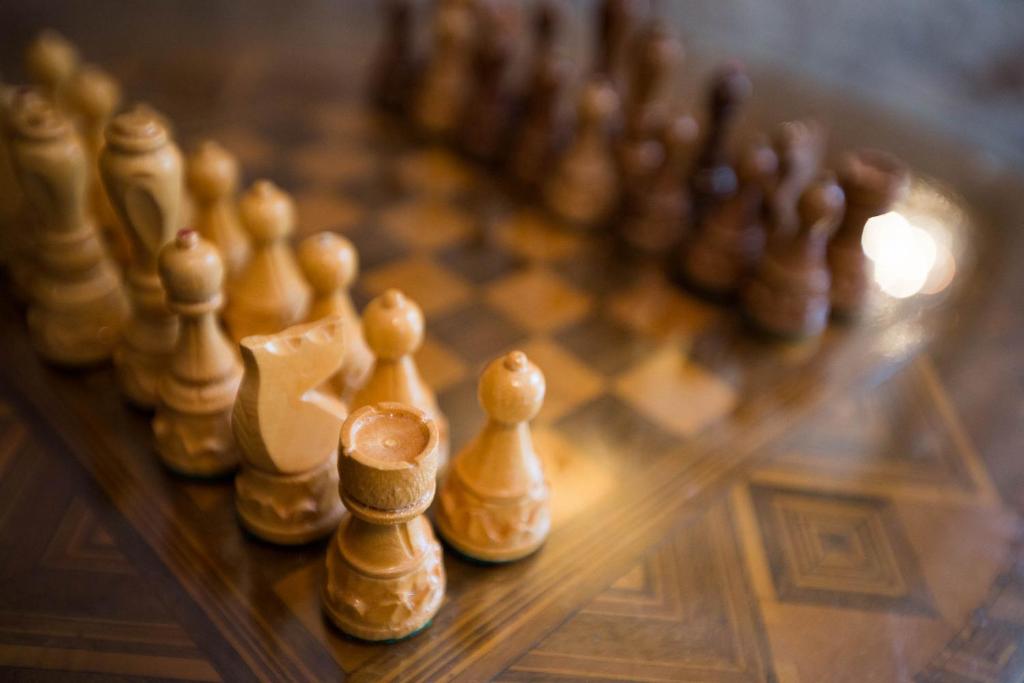 a wooden chess board with the chess pieces lined up at Room Mirella in Dubrovnik