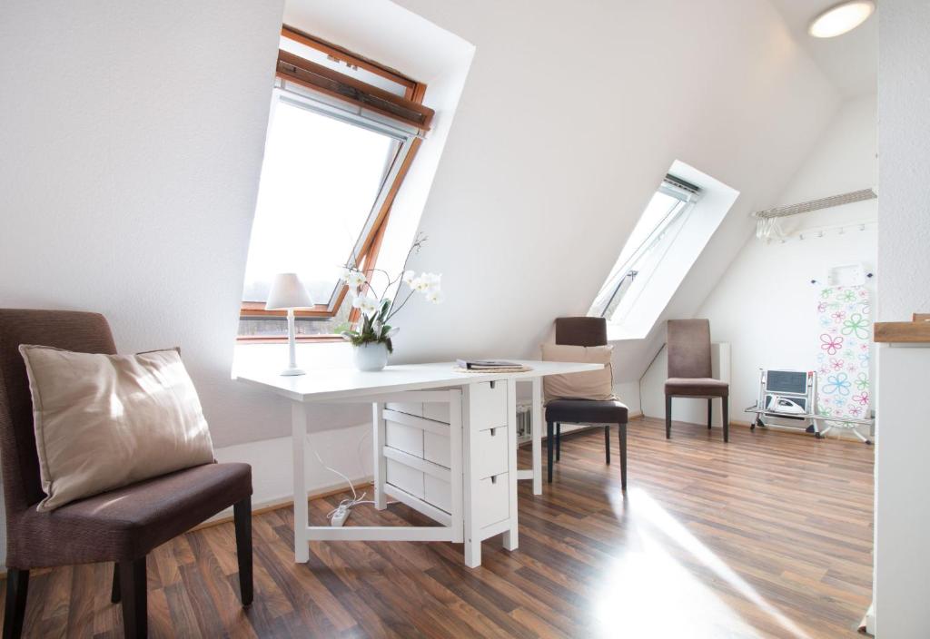 een kamer met een wit bureau en 2 stoelen bij fewo1846 - Strandresidenz Wassersleben Lee - strandnahes Studioapartment im Dachgeschoss in Harrislee