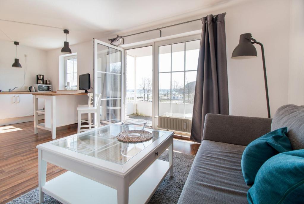 ein Wohnzimmer mit einem Sofa und einem Tisch in der Unterkunft fewo1846 Strandresidenz Wassersleben - Luv - komfortables Studio-Apartment mit Balkon und Meerblick in Harrislee