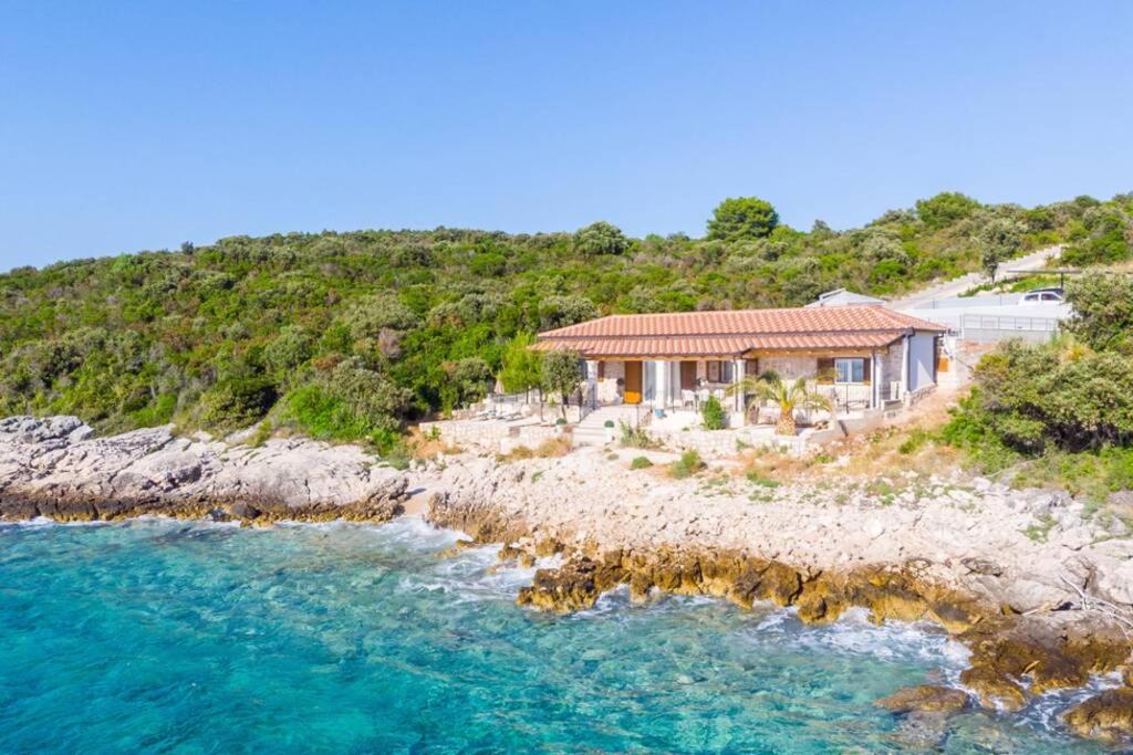 una casa en una colina junto a un cuerpo de agua en Sunset Paradise, getaway villa in private oasis, en Lovište