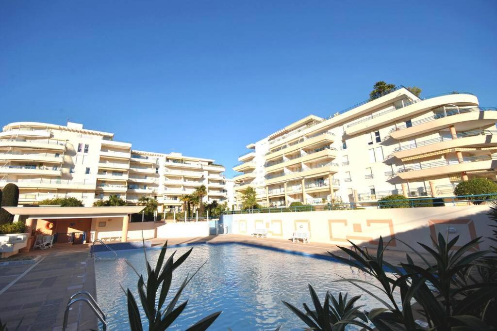 een zwembad voor sommige appartementsgebouwen bij T2 climatisé à 5 minutes à pied de la plage avec parking, piscine et wifi in Fréjus