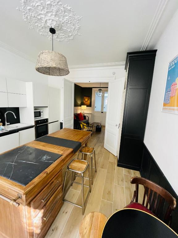 une cuisine avec une grande table et des chaises en bois dans l'établissement SON DES MOUETTES PLAGE, à Trouville-sur-Mer