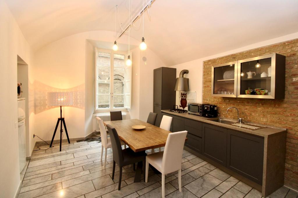 una cucina e una sala da pranzo con tavolo e sedie di Luxury Suite apartment Angiolieri a Siena