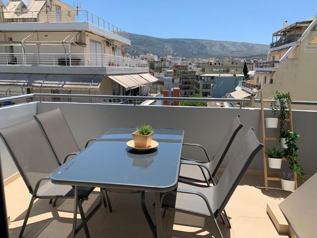 une table bleue et des chaises sur un balcon dans l'établissement MV Penthouse, à Athènes