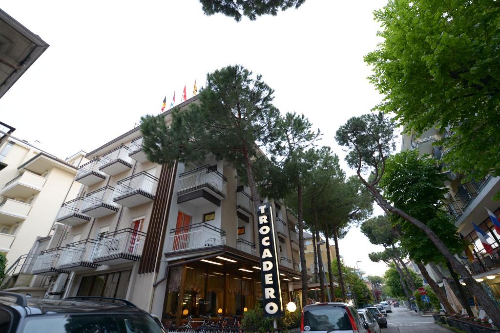 un edificio en una calle con coches aparcados delante en Hotel Trocadero en Riccione